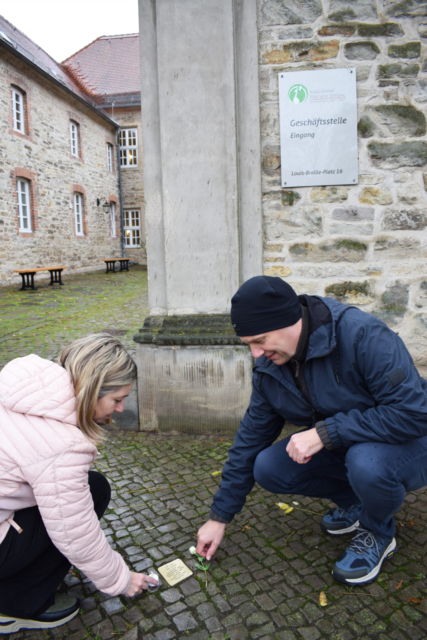Mitarbeiter gedenken Ida Böhm am Stolperstein vor der Geschäftsstelle der Kanzler von Pfau'schen Stiftung