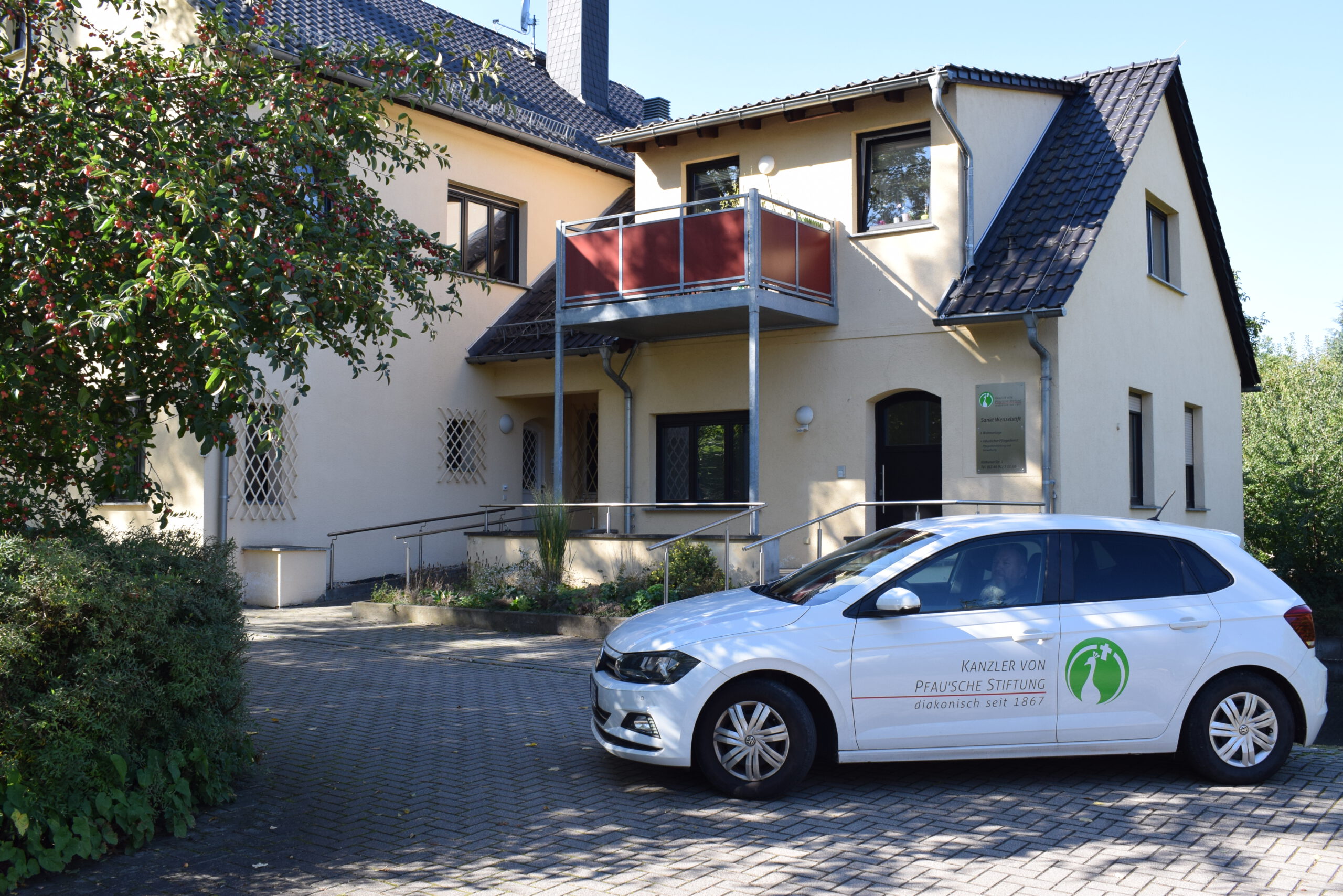 Pflegeauto steht vor einem Haus