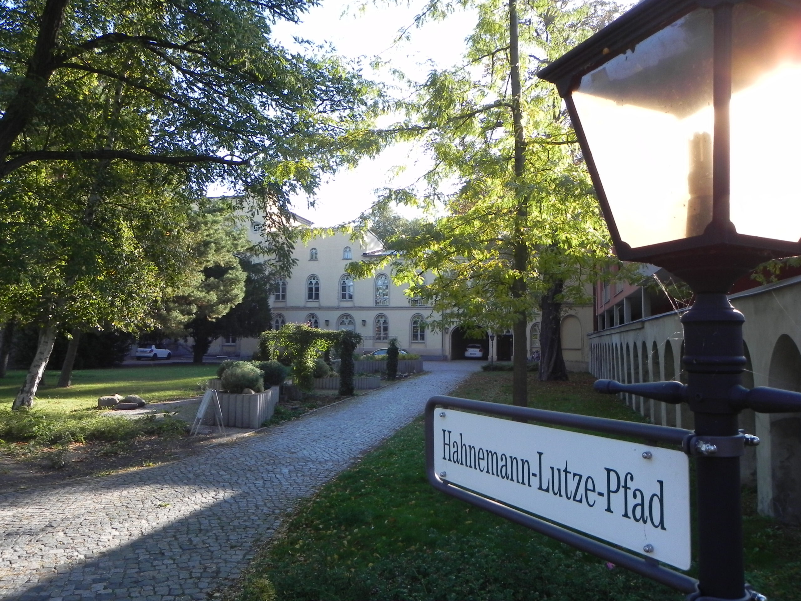 Garten mit Bäumen und einem Weg zum Hahnemanstift Köthen