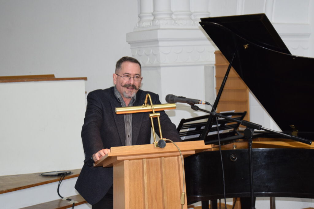 Hospiztag in Bernburg 2025, der Pfarrer steht am Rednerpult und sagt ein paar Worte