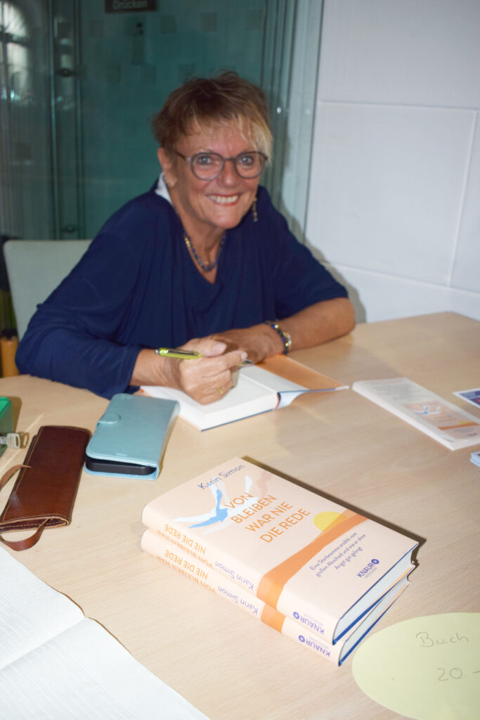 Hospiztag in Bernburg 2025, Karin Simon signiert ihr Buch "Von Bleiben war nie die Rede."