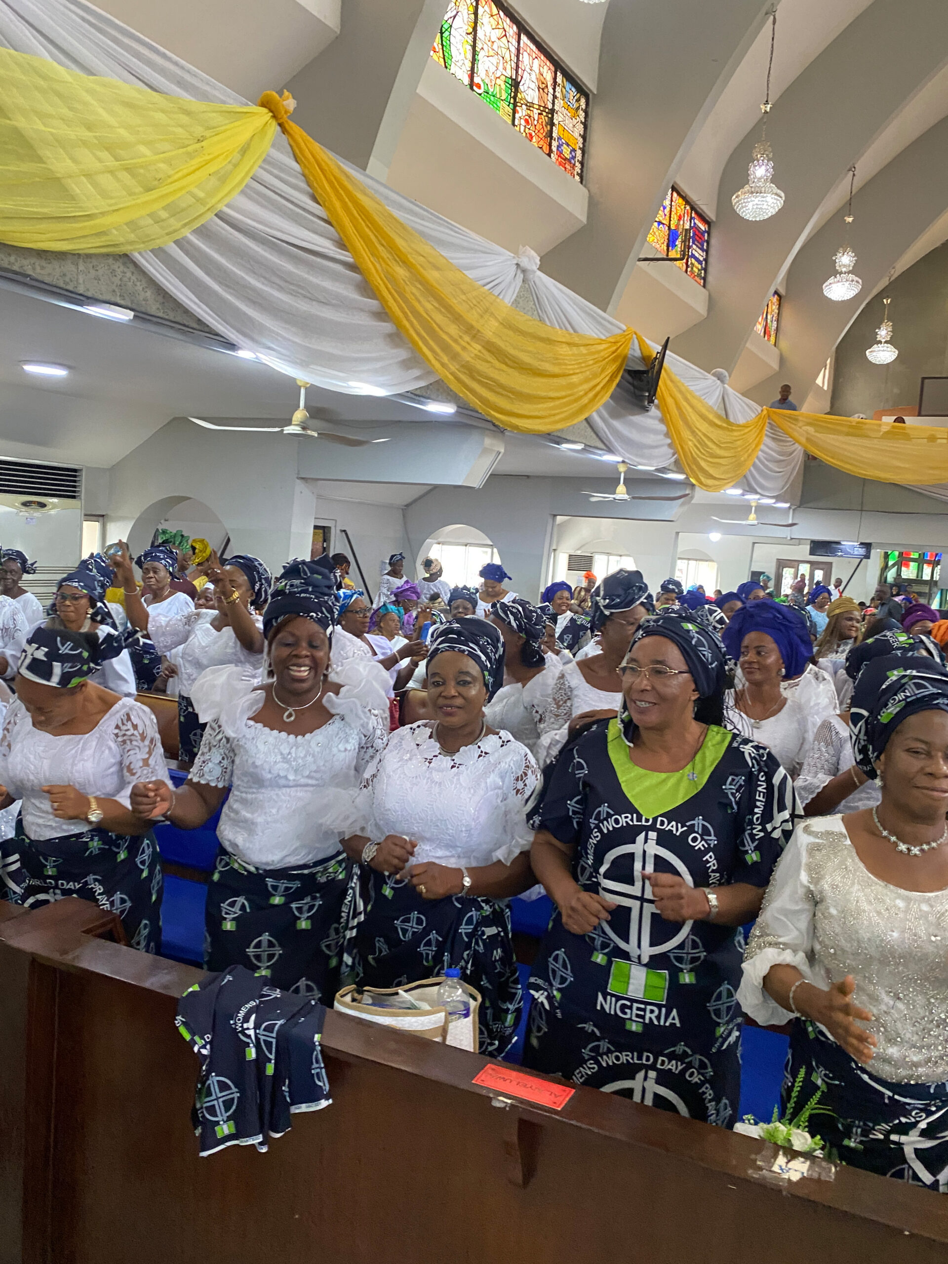 Das Bild zeigt einen Gottesdienst in Nigeria mit vielen festlich gekleideten Frauen
