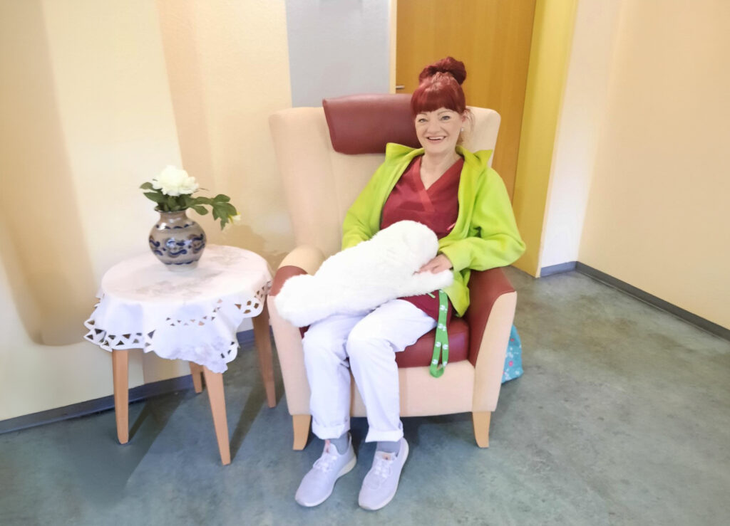 Robbe Paro auf dem Schoß einer Mitarbeiterin