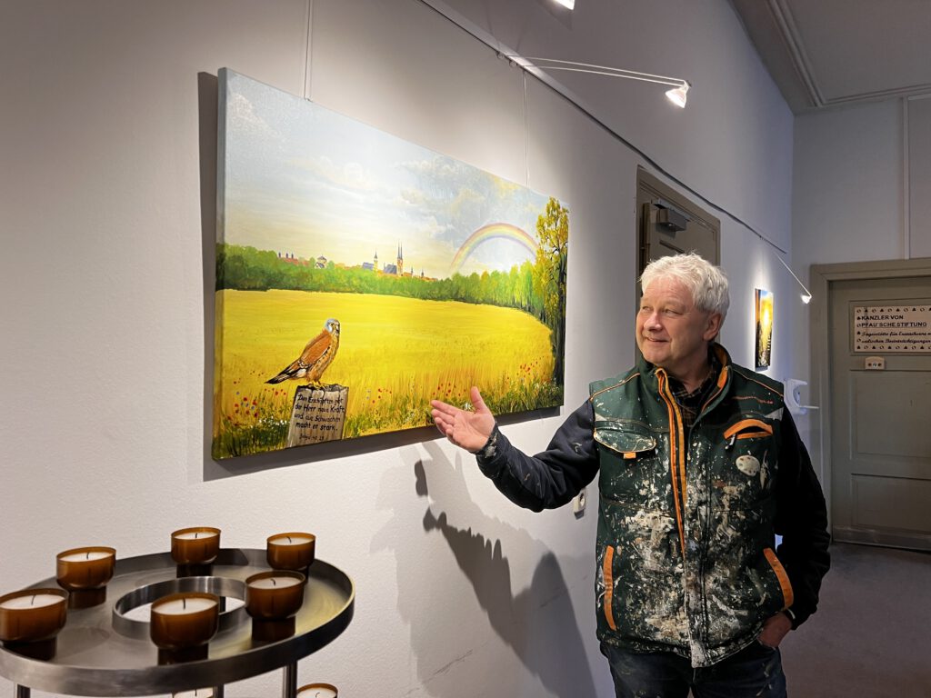 Kunstmaler Steffen Rogge zeigt ein Bild in der Galerie