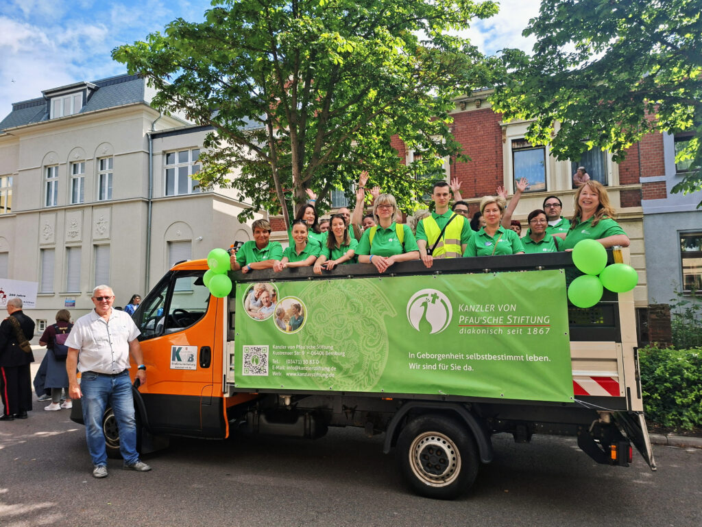 Das Team der Kanzler von Pfauschen Stiftung auf dem Umzugswagen.